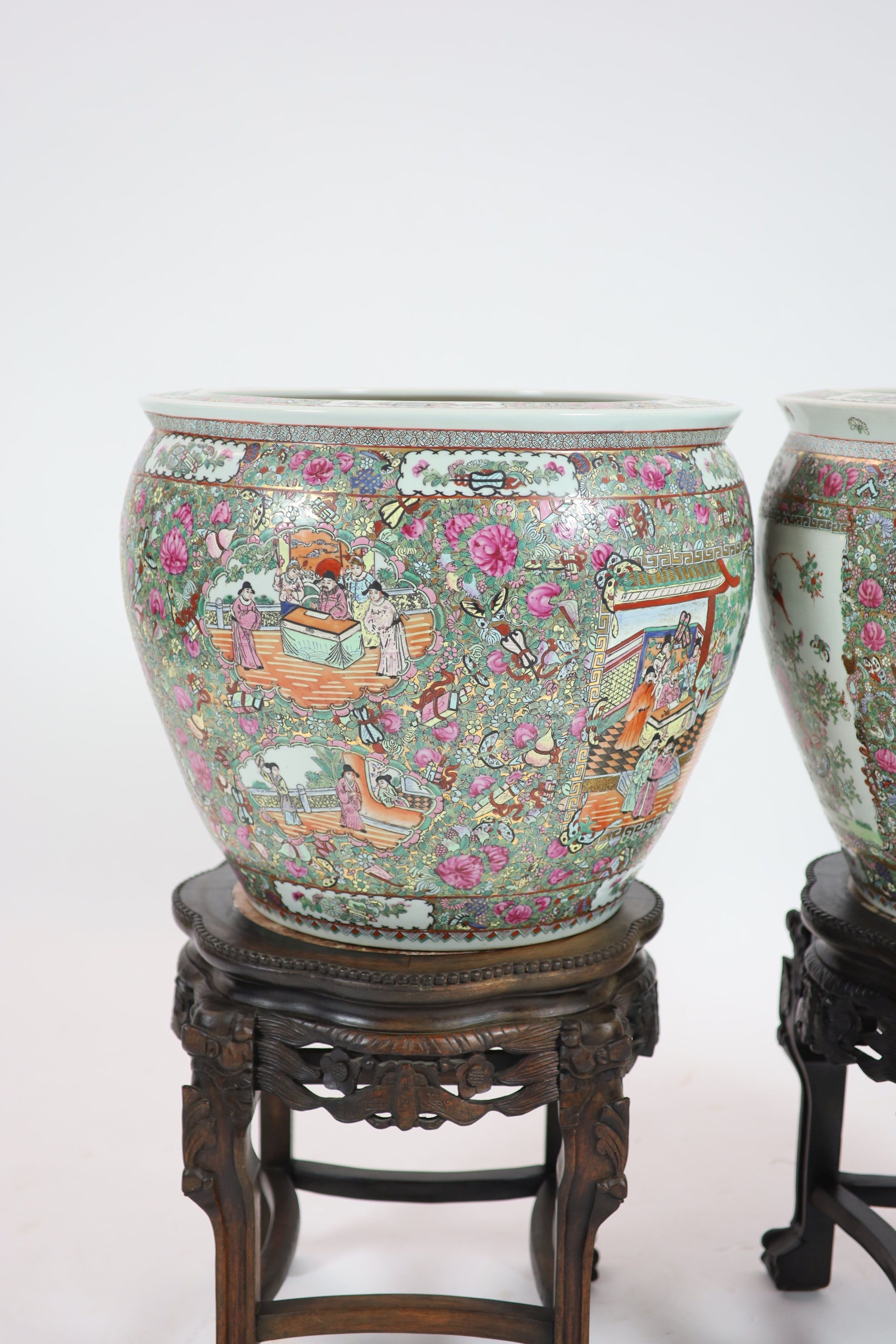 A pair of Chinese famille rose fish bowls on ebonised marble inset stands, diameter 56cm, total height 91cm